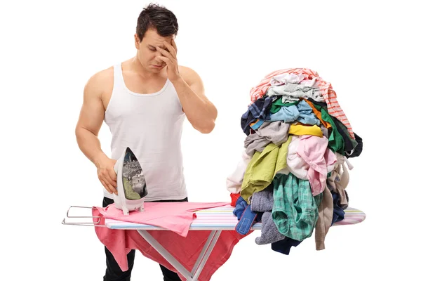 Homem triste ao lado de uma pilha de roupas — Fotografia de Stock