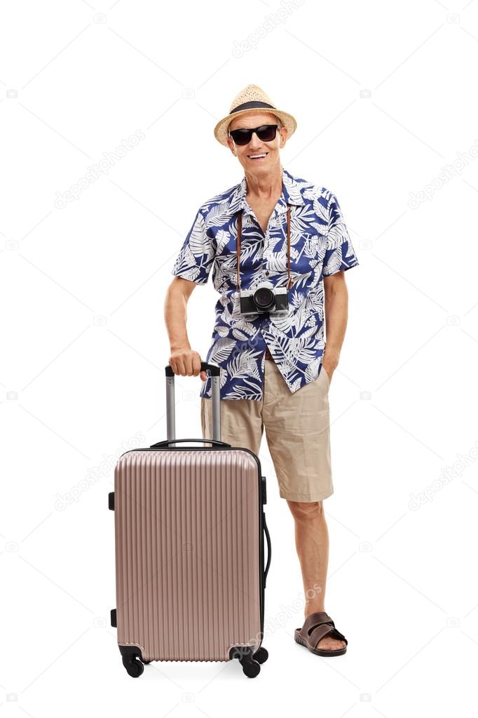 Senior tourist posing with a suitcase