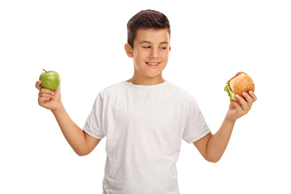 Ragazzo con in mano una mela e un panino — Foto Stock