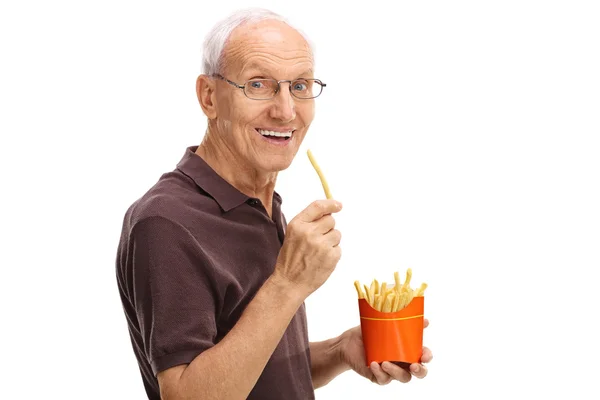 Senior man eating fries — Stock Photo, Image