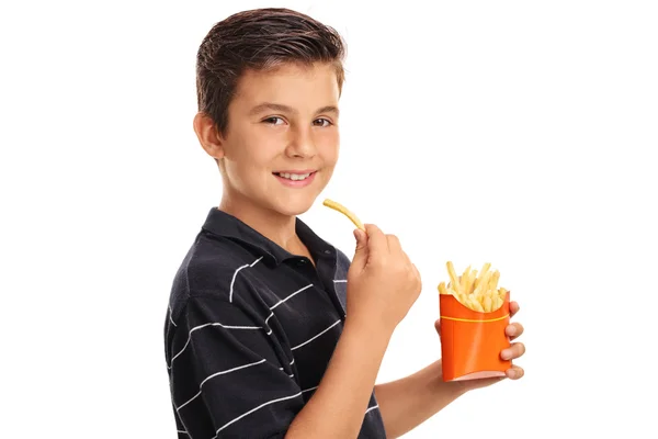 Usměvavý chlapec jíst hranolky — Stock fotografie
