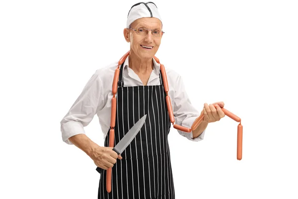 Butcher posing with knife and sausages — Stock Photo, Image