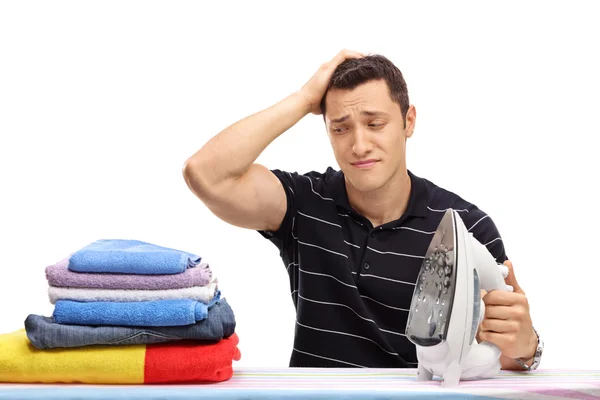 Cara coçando a cabeça e olhando para roupas — Fotografia de Stock