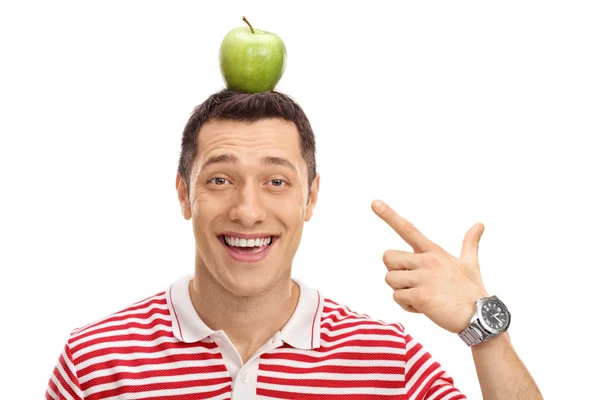 Chico feliz apuntando a una manzana en su cabeza —  Fotos de Stock