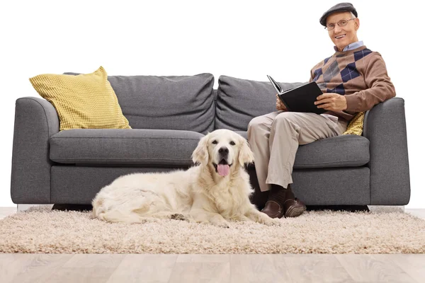 Senior reading with his dog — Stock Photo, Image