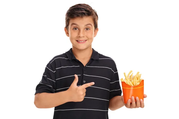 Pojken håller en påse med pommes frites och pekar — Stockfoto