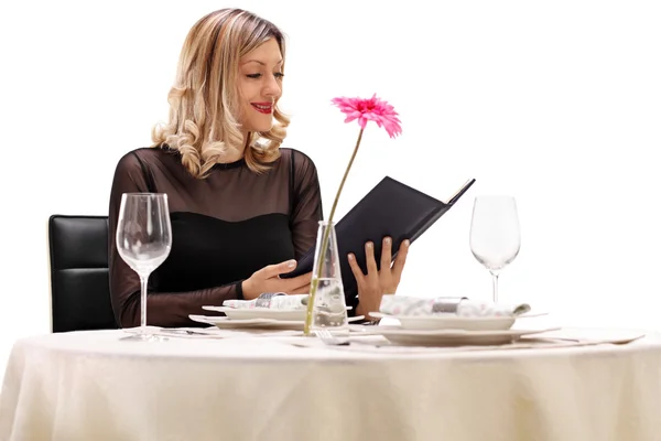 Frau am Restauranttisch liest Speisekarte — Stockfoto