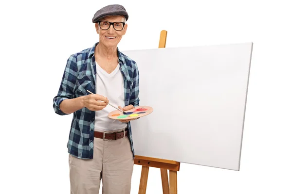 Painter posing next to a canvas — Stock Photo, Image