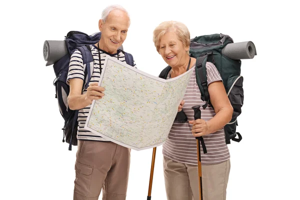 Elderly hikers looking at generic map — Stock Photo, Image