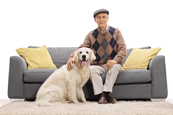 Hombre sentado en el sofá y posando con su perro — Foto de Stock