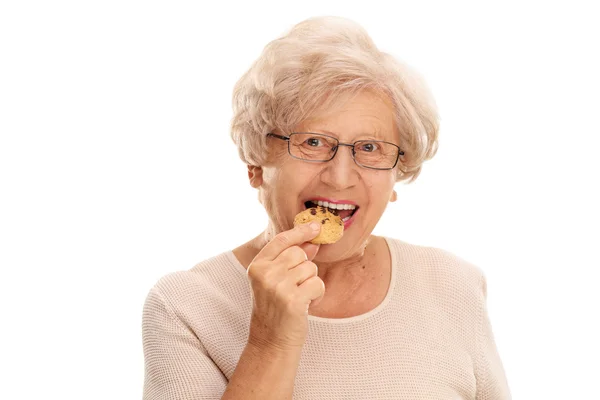 Senior kobieta jedzenia ciasteczko — Zdjęcie stockowe