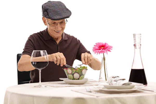 Senior at a restaurant table eating a salad — Stock Photo, Image