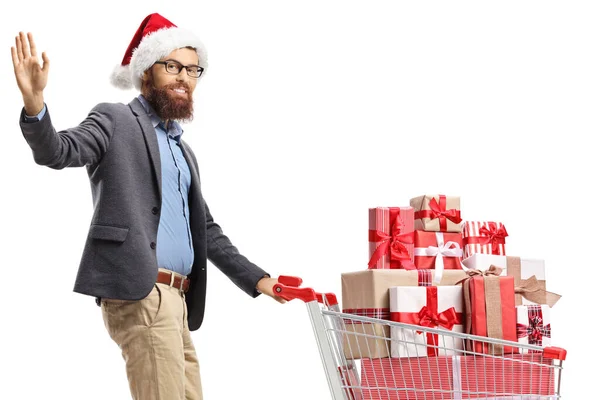 Bärtiger Mann Mit Weihnachtsmütze Winkt Und Läuft Mit Einem Einkaufswagen — Stockfoto