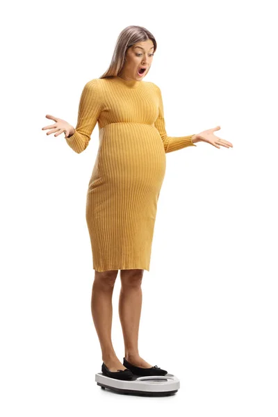 白い背景に隔離された体重計の上に立つショックで驚くべき妊婦 — ストック写真