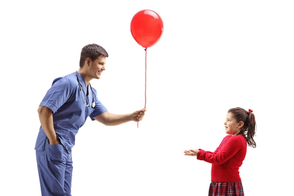 Médico Dando Balão Vermelho Para Uma Menina Isolada Fundo Branco — Fotografia de Stock