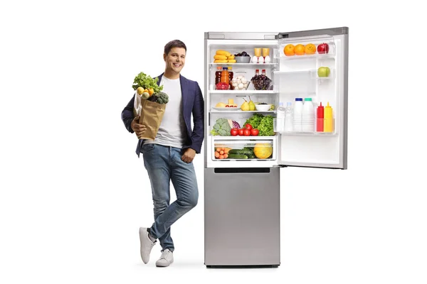 Full Length Portrait Young Man Grocery Bag Leaning Open Fridge — Stock Photo, Image