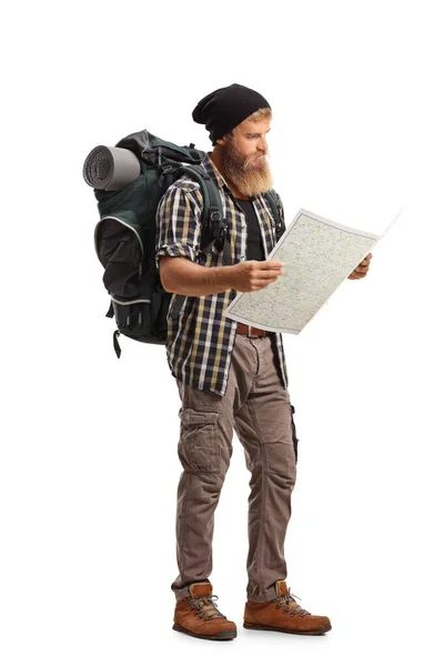 一个留着胡子 背着背包的徒步旅行者的全景照片 他看了看地图 地图被白色背景隔开了 — 图库照片