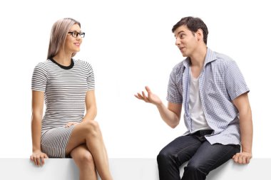 Kadın ve erkek bir panelde oturuyor ve beyaz arka planda izole bir şekilde konuşuyorlar.