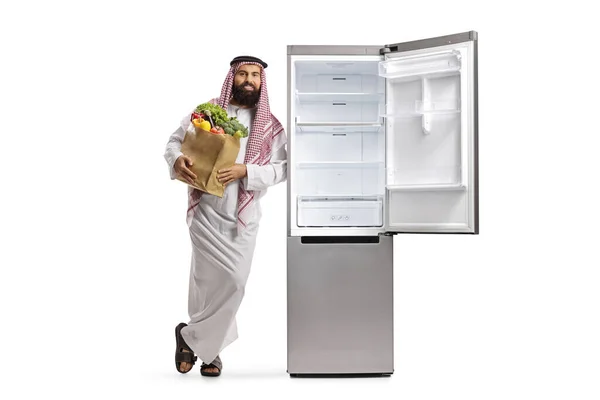 Арабський Чоловік Продуктовою Сумкою Спирається Порожній Відкритий Холодильник Ізольований Білому — стокове фото