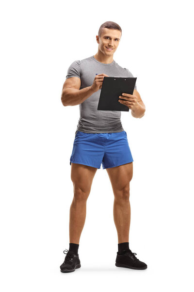 Полный портрет мышечного инструктора фитнеса, пишущего на планшете, изолированном на белом фоне