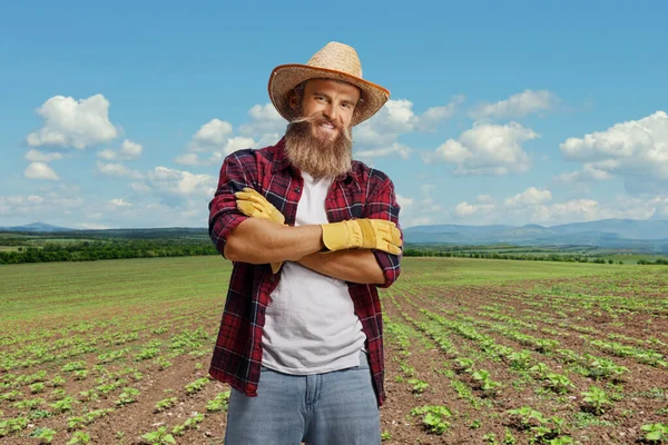 若い髭を生やした農夫が腕を組んで畑でポーズをとっている — ストック写真