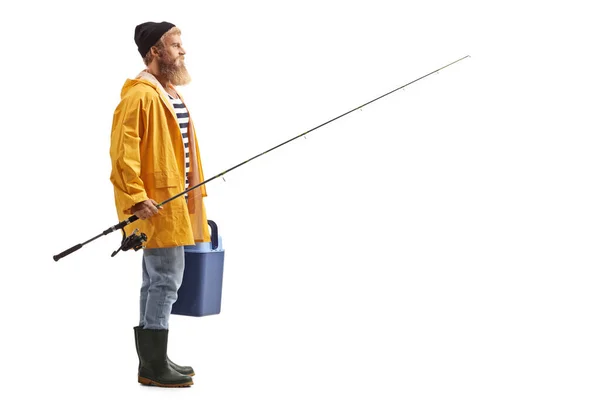 穿着黄色雨衣的渔夫拿着手提式冰箱和一根白色背景的钓竿 — 图库照片