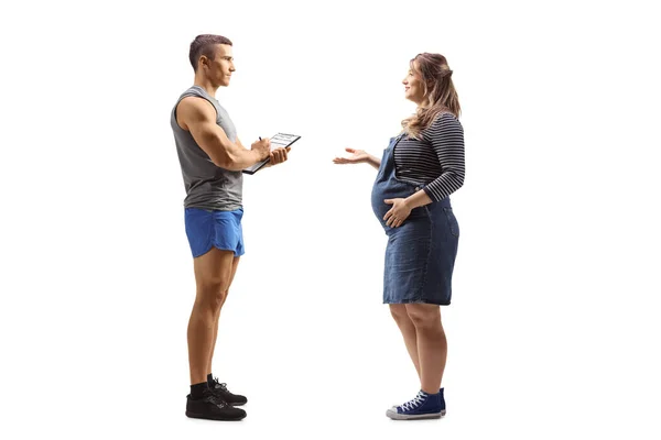 一名孕妇与一位白色背景的健身教练交谈时的全长照片 — 图库照片
