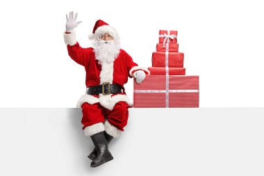 Beyaz bir pankartta duran ve beyaz arka planda izole edilmiş el sallayan Noel Baba 'nın tam boy portresi.