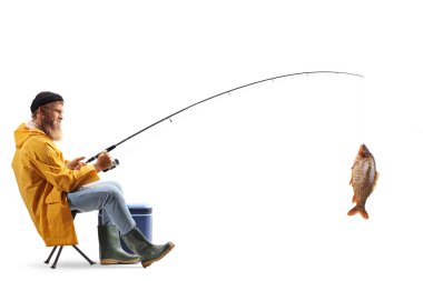 Sandalyeye oturmuş beyaz arka planda balık yakalayan genç bir balıkçının tam boy profil çekimi.