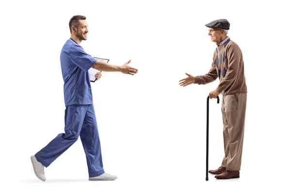 Pełny Profil Męskiego Pracownika Służby Zdrowia Witającego Starszego Mężczyznę Chodzącą — Zdjęcie stockowe
