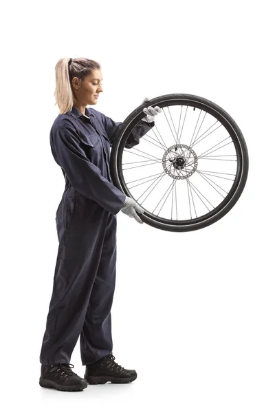 白地に隔離された自転車の車輪を持つ女性の自転車整備士の完全な長さのショット — ストック写真