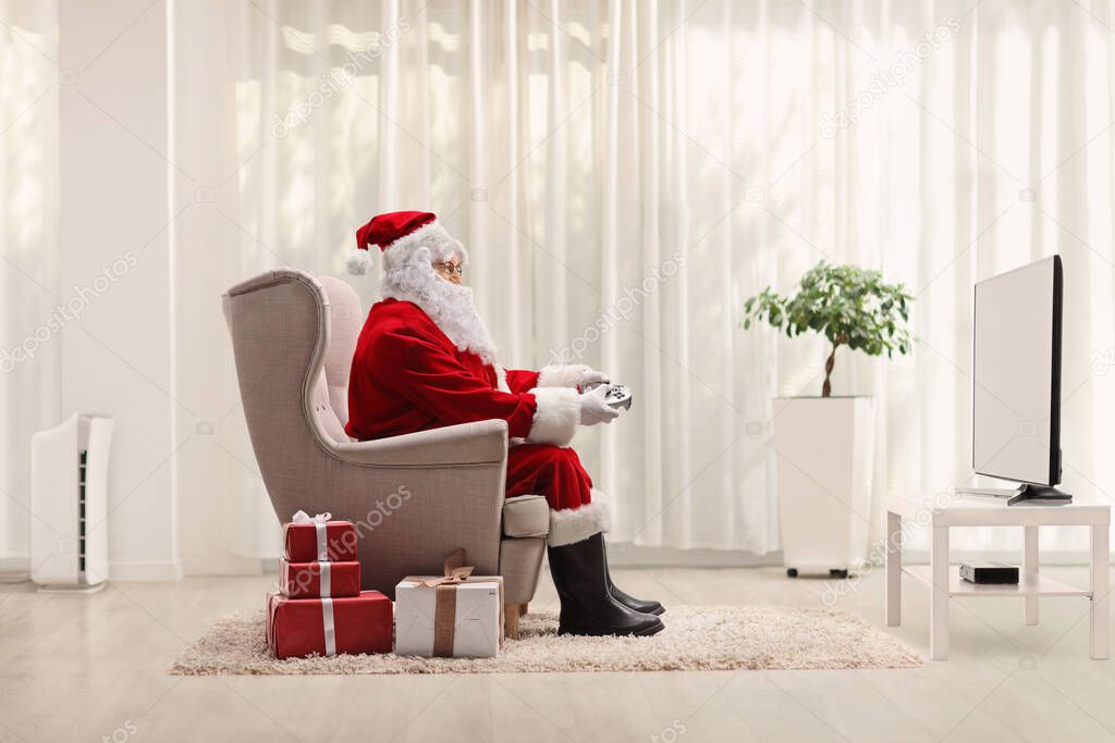Santa claus with a joystick playing video games at home