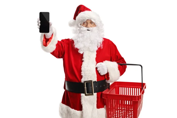 Der Weihnachtsmann Hält Einen Einkaufskorb Und Zeigt Ein Smartphone Vor — Stockfoto
