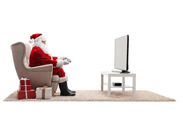 Santa Claus Κάθεται Μια Πολυθρόνα Και Παίζει Βιντεοπαιχνίδια Στην Τηλεόραση — Φωτογραφία Αρχείου