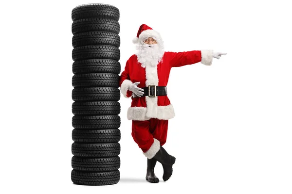 Full Length Portrait Santa Claus Leaning Pile Tires Pointing Side — Stock Photo, Image