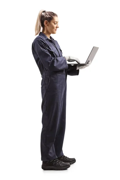 白い背景に隔離されたラップトップコンピュータ上の一様入力で女性整備士の労働者の完全な長さプロファイルショット — ストック写真