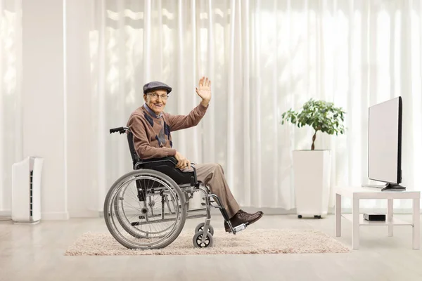 Starší Zdravotně Postižený Muž Mávající Invalidního Vozíku Před Televizí Doma — Stock fotografie