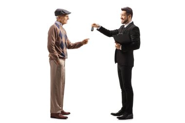 İş adamı, beyaz arka planda izole edilmiş yaşlı bir adama araba anahtarı veriyor.