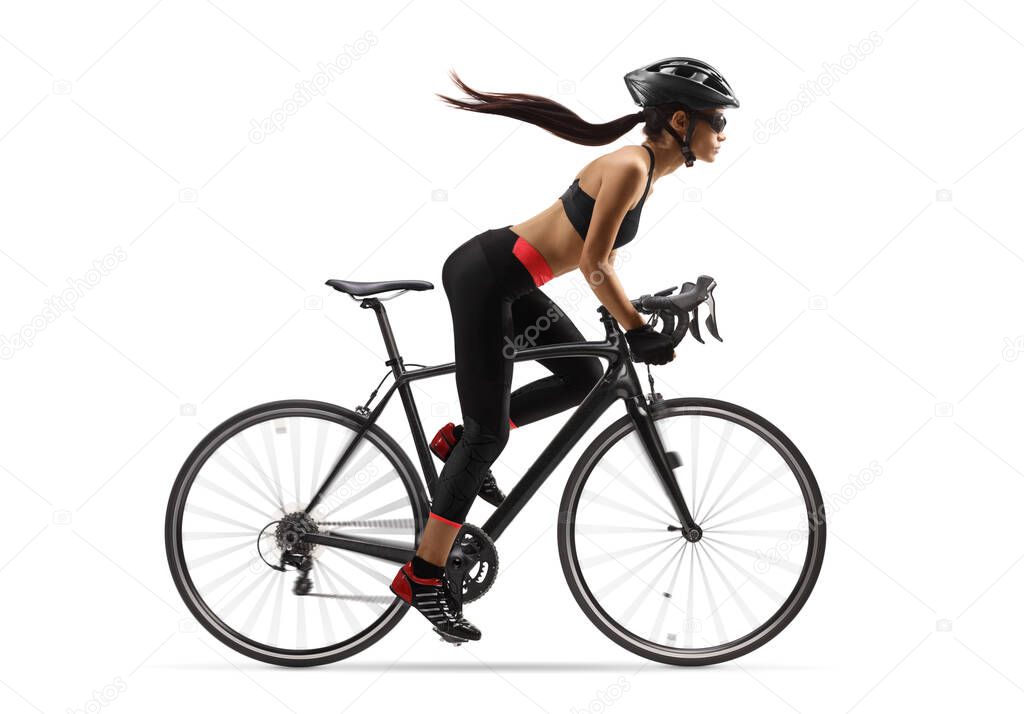 Full length profile shot of a female cyclist with a long ponytail waving, riding a road bicycle isolated on white background