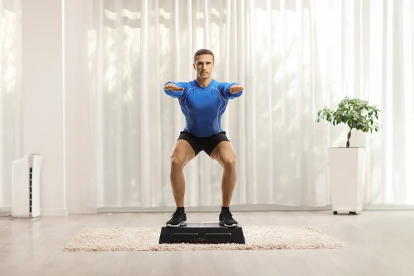 Evde Aerobik Bir Platformda Egzersiz Yapan Kaslı Genç Bir Adam — Stok fotoğraf