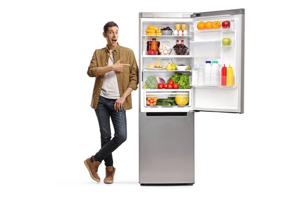 Портрет Молодого Человека Указывающего Холодильник Едой Изолированной Белом Фоне — стоковое фото