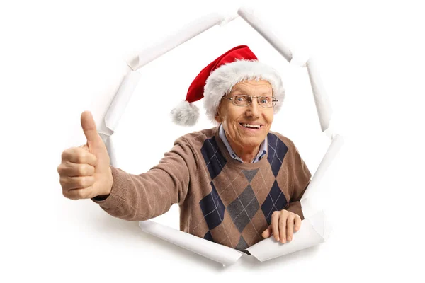 Пожилой Человек Шляпе Санта Клауса Прорывается Через Бумагу Делает Большой — стоковое фото