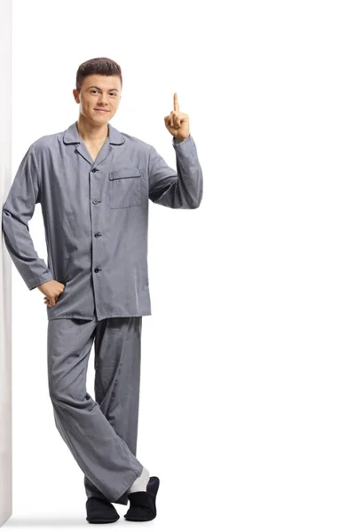 Full Length Portrait Young Man Pajamas Leaning Wall Pointing Isolated — Stock Photo, Image