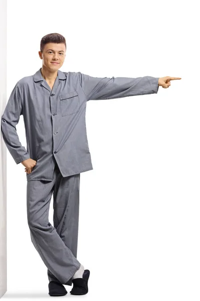 Full Length Portrait Male Teenager Pajamas Leaning Wall Pointing Side — Stock Photo, Image