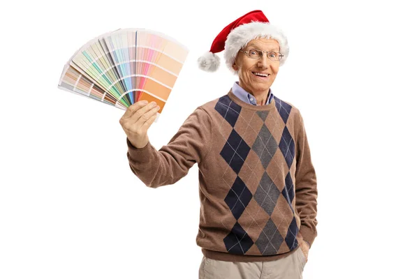 Пожилой Человек Шляпе Санта Клауса Держащий Цветной Образец Смотрящий Камеру — стоковое фото