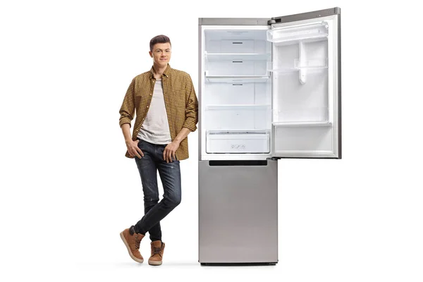 Портрет Обычного Подростка Клетчатой Рубашке Джинсах Опирающегося Пустой Холодильник Белом — стоковое фото