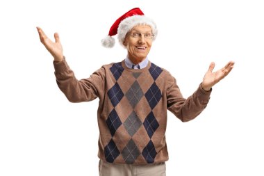 Neşeli yaşlı adam hoş geldin jesti yapıyor ve beyaz arka planda izole edilmiş Noel Baba şapkası takıyor.