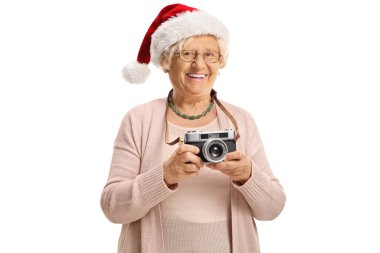 Beyaz arka planda izole edilmiş Noel Baba şapkası takan klasik kameralı yaşlı bir kadın.