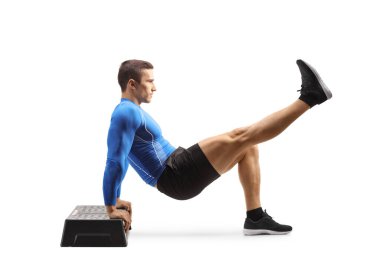 Beyaz arka planda izole edilmiş bir basamakta egzersiz yapan fit ve güçlü bir adamın tam boy portresi.