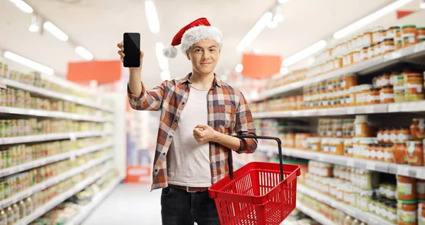 Kerst Kerstmuts Een Supermarkt Met Een Mandje Een Mobieltje — Stockfoto